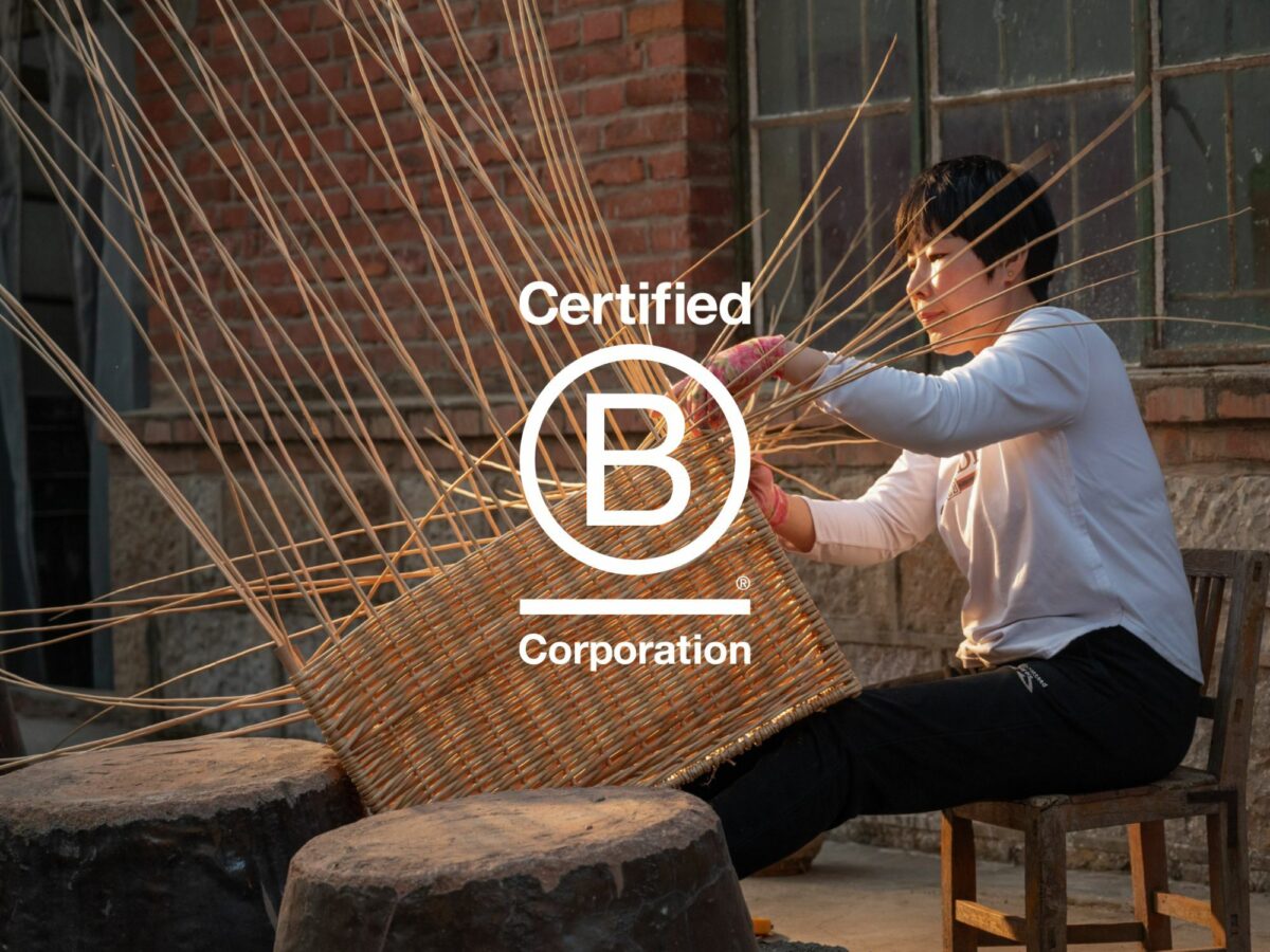 A woman weaving a wicker hamper from willow strands