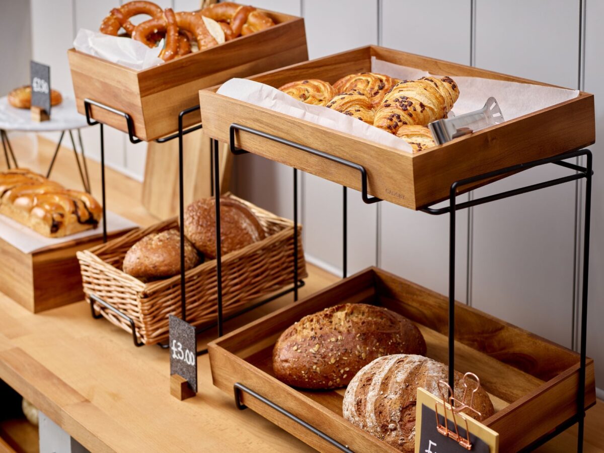 Counter display stands made of powder coated metal with Acacia wooden crates filled with pastries and bakery items