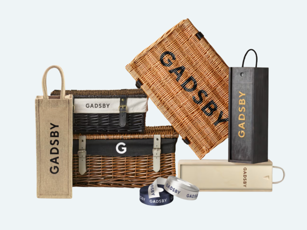 Gadsby branding shown on a variety of products including wicker hamper baskets, wine bottle boxes, ribbon and jute bags