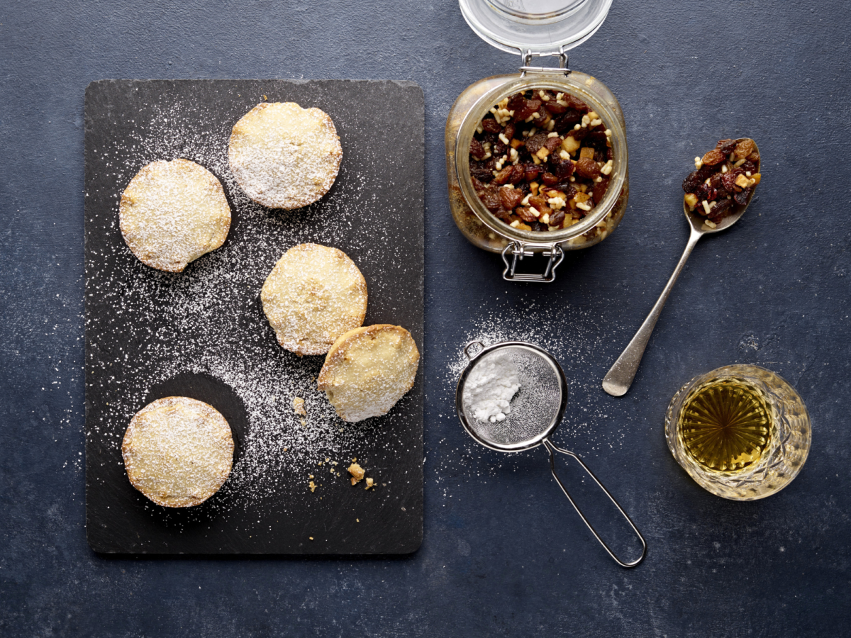 Flat lay of mince pies on a black slate board