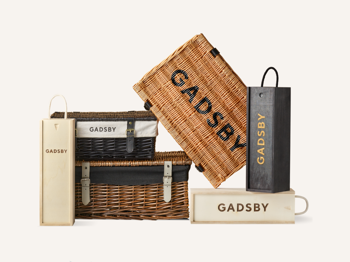 A range of wicker hampers and wooden bottle boxes with Gadsby branding on them