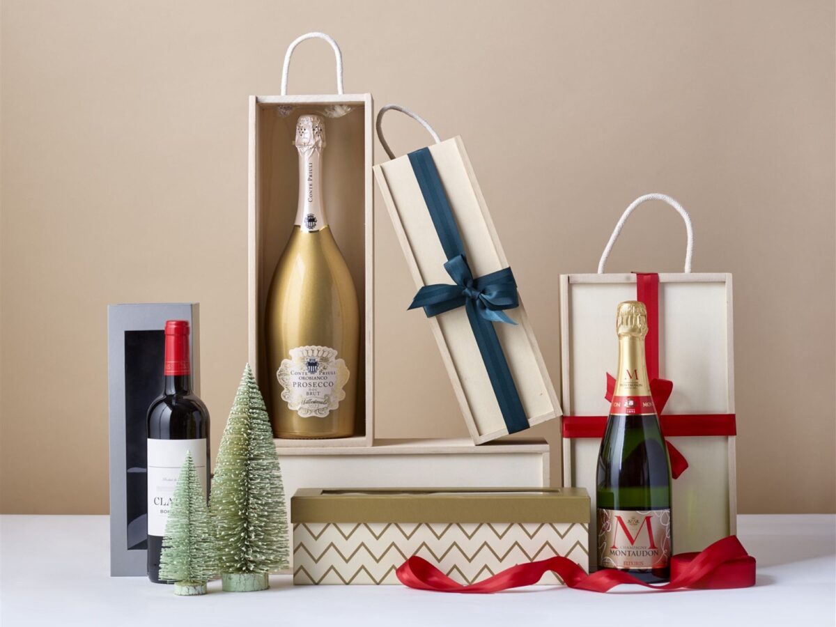 A range of wooden bottle boxes and cardboard bottle boxes with bottles of champagne, prosecco and wine.