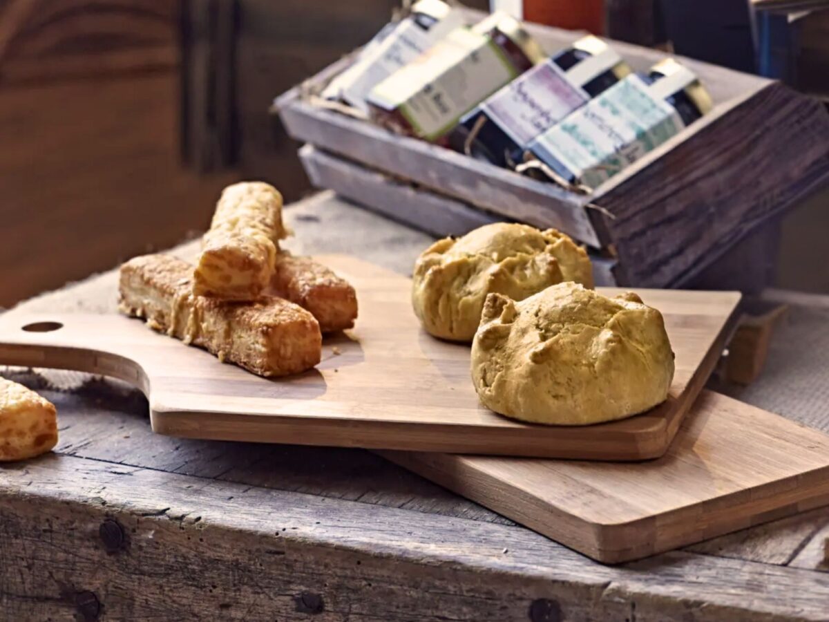 Wooden bamboo boards on a wooden surface displaying a variety of pastries
