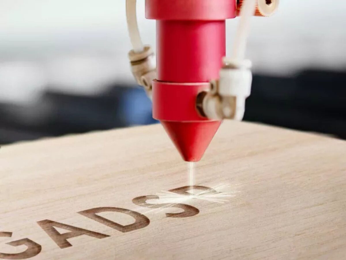 Laser engraving machine etching into a wooden box